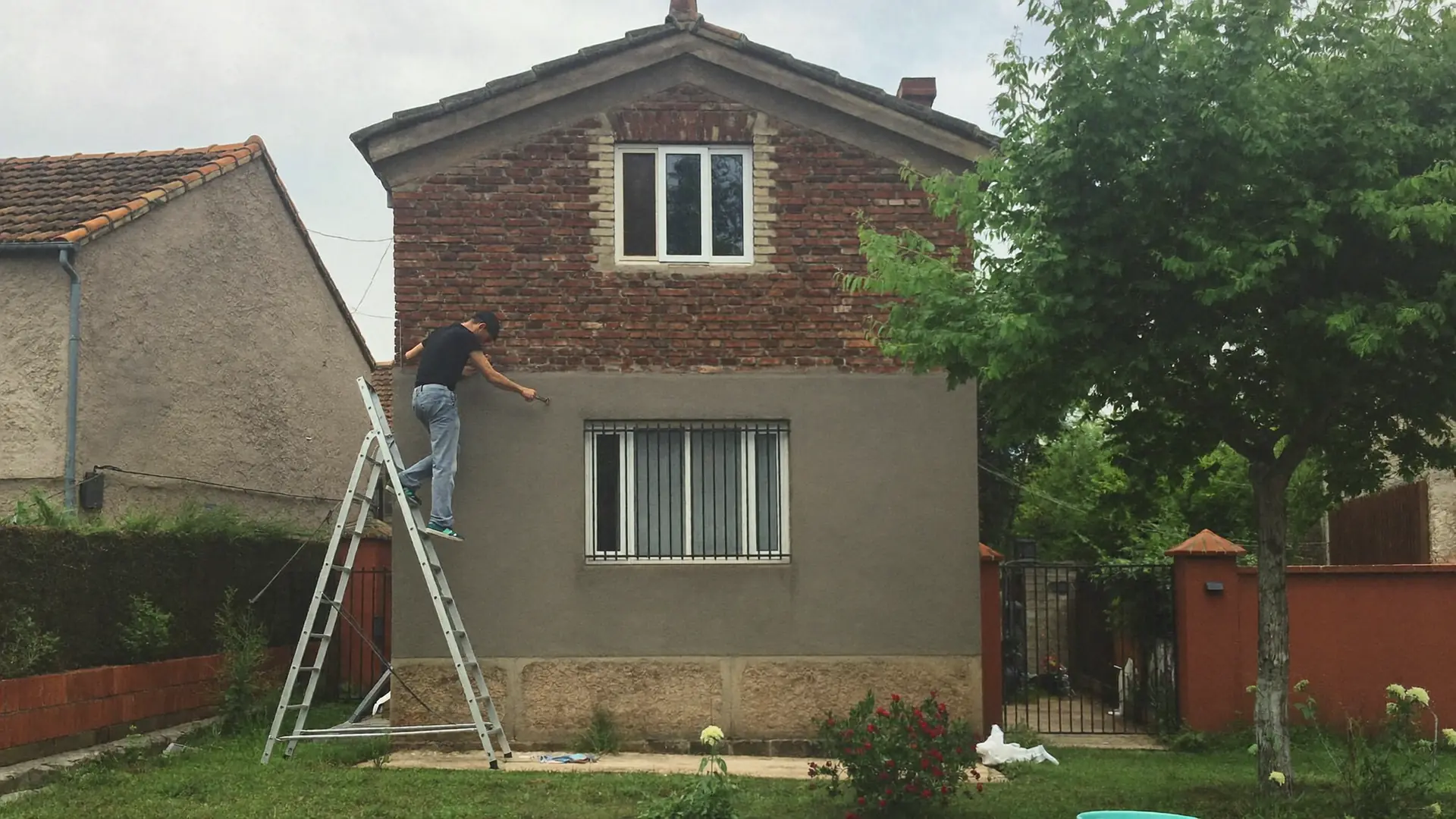 Pintor en escalera pintando una casa unifamiliar del oeste de Terrassa