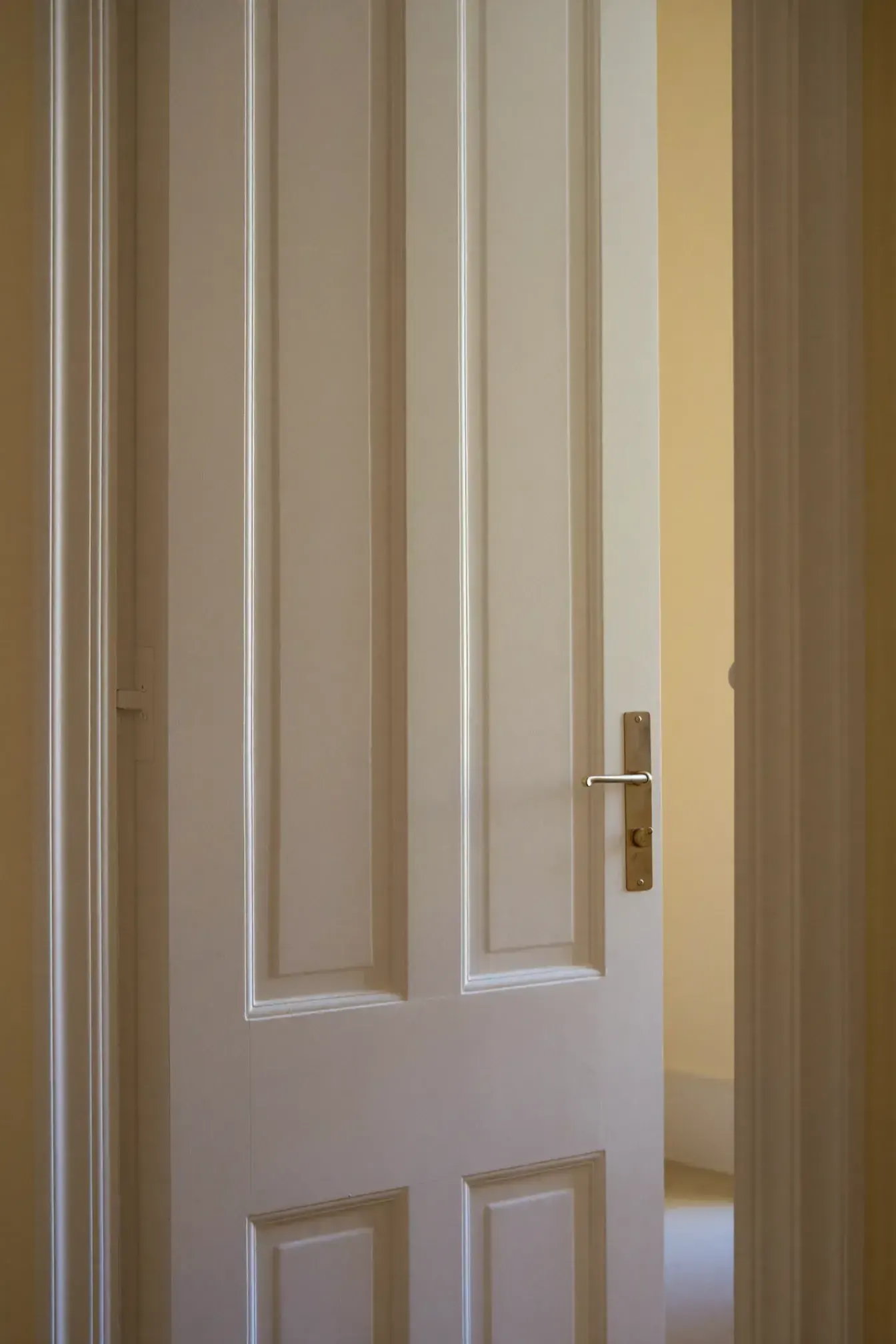 Puerta lacada en blanco en pasillo con paredes crema
