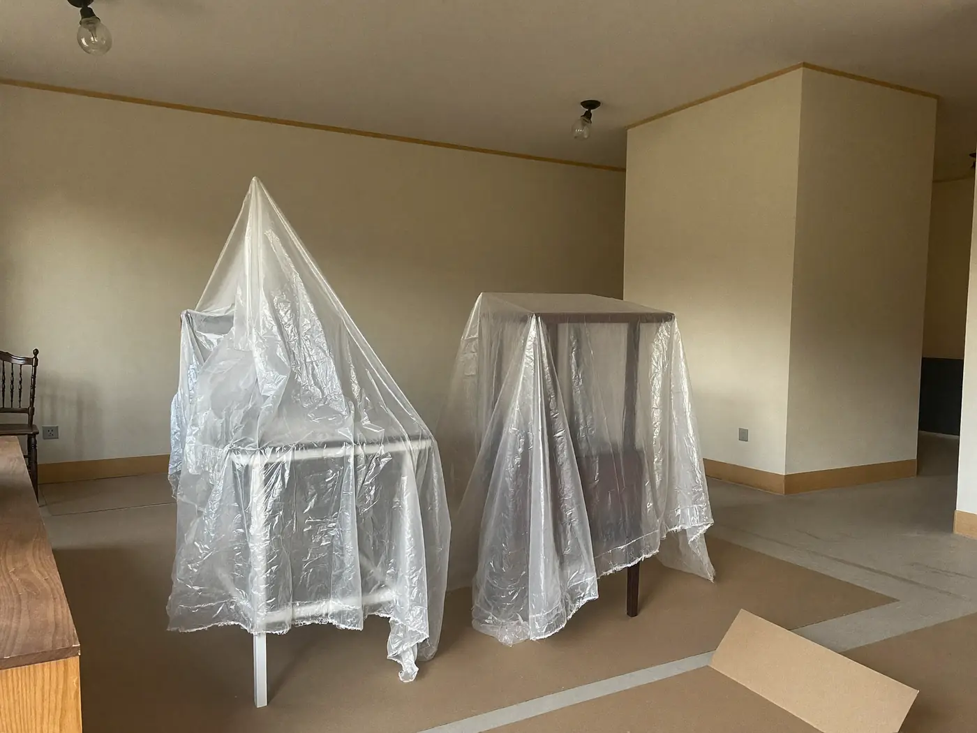 Muebles agrupados y cubiertos con plástico antes de pintar en Terrassa